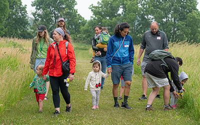 Adults and children walking along a prairie trail